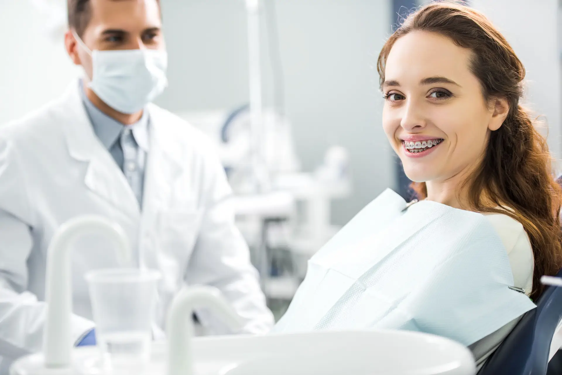 Smiling patient wearing braces at Olympic Park Smiles Dental in Calgary